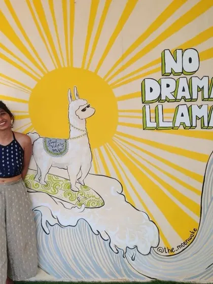 Here I am with one of my favorite quirky murals, the 'No Drama Llama', at a hostel in Goa. This piece was designed to be a fun, memorable photo opportunity for guests, and I was so happy to see it still bringing smiles six years after I first painted it.