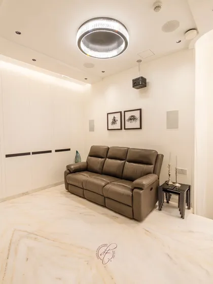 A wide shot of the home theater, showcasing the clean lines, marble flooring, and thoughtfully designed lighting that complete the cozy and high-end atmosphere.