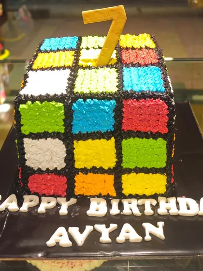A fun and challenging Rubik's Cube cake, perfect for a puzzle lover's birthday. This sculpted cake is meticulously decorated with colorful buttercream squares to replicate the iconic toy, demonstrating our precision and creativity with novelty designs.