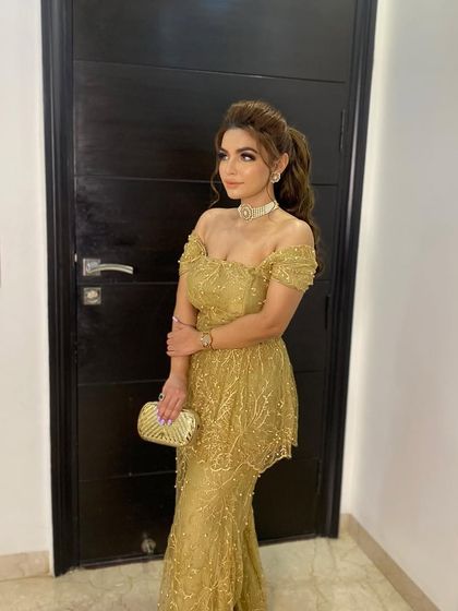 A golden girl moment with a messy high ponytail. This is a glamorous and confident look for a cocktail party or reception.