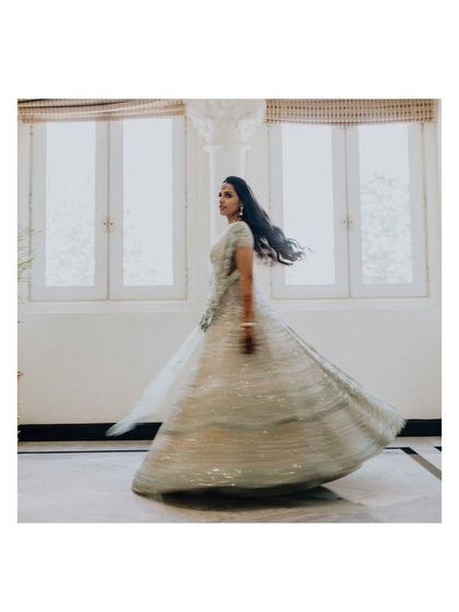 A beautiful shot of the bride, Sanjana, twirling in her stunning lehenga, creating a sense of movement and joy.