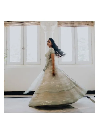A beautiful shot of the bride, Sanjana, twirling in her stunning lehenga, creating a sense of movement and joy.