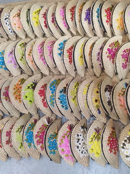 An impressive display of our handcrafted fan-shaped clutches, ready for shipping. The sheer variety in color and floral embroidery highlights the custom, artisanal nature of our products, perfect for bulk orders and unique gifting.