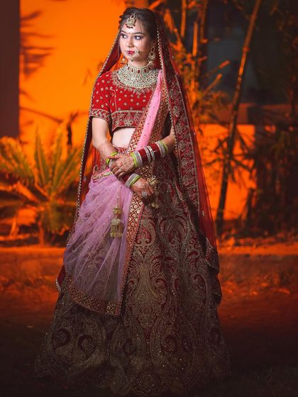 A full-length shot that captures the bride's entire look against a warm, glowing background.