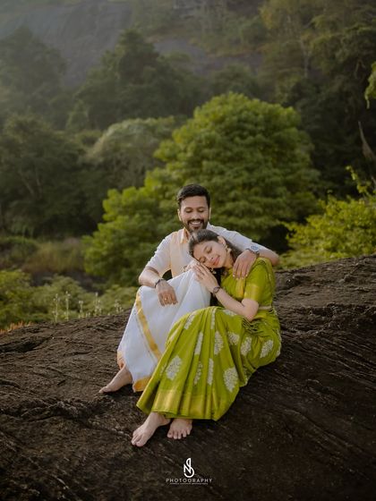 A peaceful moment of rest on a large rock overlooking the hills. The traditional green saree complements the natural surroundings perfectly.