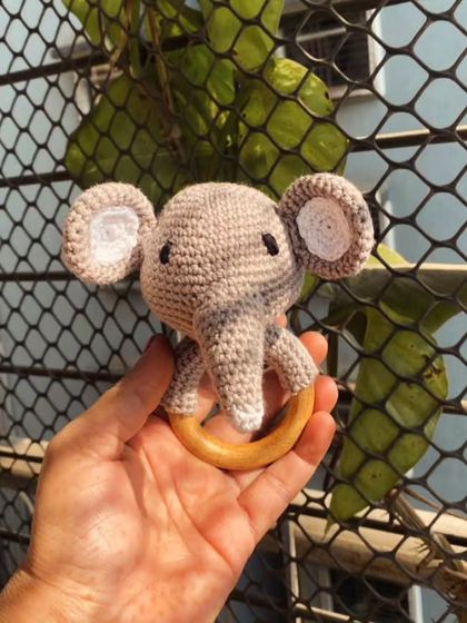 A close-up of my elephant rattle, held to show its size. It's lightweight and easy for little hands to hold, making it a perfect first toy.