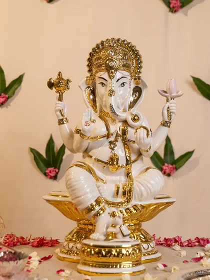 This stunning porcelain Ganesha is finished with rich gold accents that highlight his divine crown and ornaments. Seated on a lotus, this idol radiates a sense of calm authority and is perfect for a prominent place in your home.