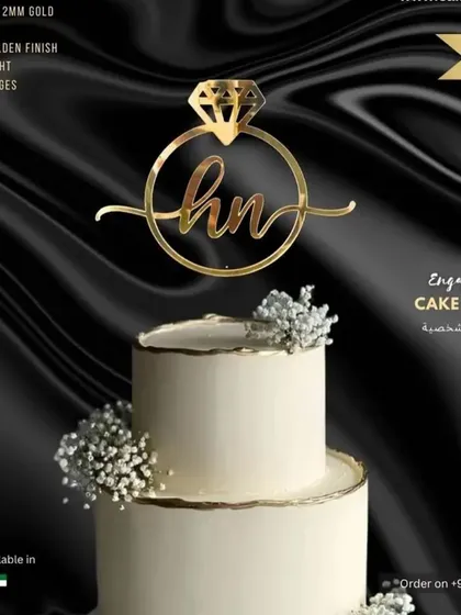 A mockup of the 'hn' engagement ring topper on a stylish black and white cake, creating a dramatic and elegant look.