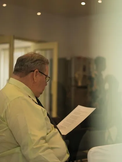 A participant engrossed in reading a poem during the award ceremony.
