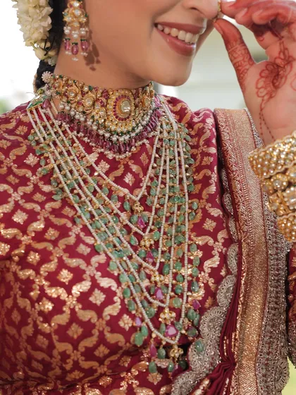 A close-up on the magnificent layered necklace and brocade blouse, key elements of this traditional bridal look.
