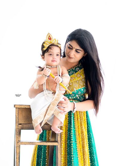 A beautiful mother-son portrait against a simple white background, letting their festive outfits shine.