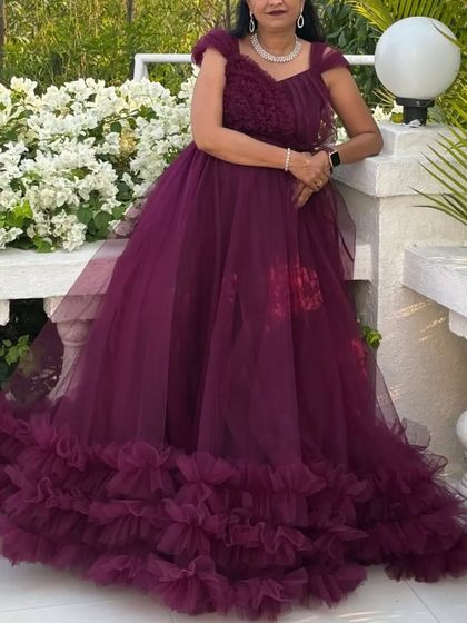 This beautiful wine-colored gown features a detachable bottom tail with dense ruffles, allowing you to switch from a grand look to a more comfortable one.