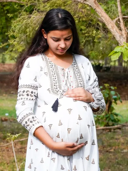 A loving downward glance at the baby bump. This pose is full of emotion and anticipation for the new arrival.