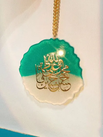 The light catching the gold calligraphy on the two-tone car hanging.