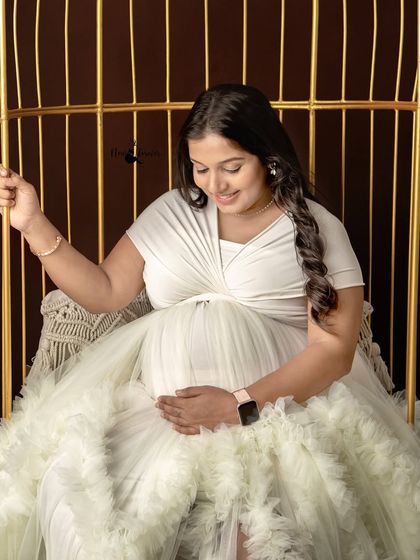 Seated on the golden swing in my studio, this mom-to-be shares a sweet, downward glance at her belly. This prop adds a touch of whimsy and elegance to any session.