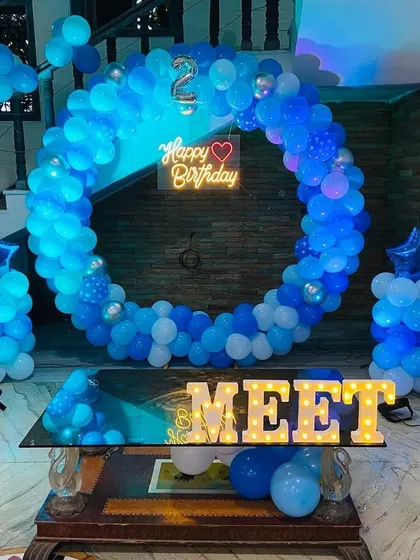 An illuminated view of the Doraemon birthday setup, showing how the neon sign and marquee letters light up the space.