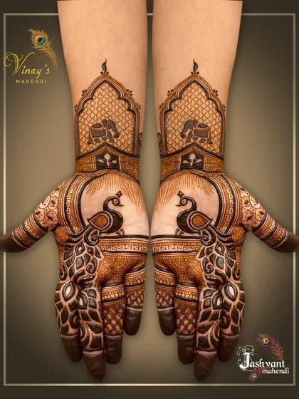 A classic symmetrical design with bold peacocks on the palms and elephants in arches on the wrists.