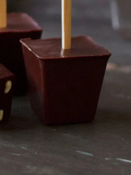 A close-up of our solid chocolate blocks on a stick, embossed with the L'inoui 'L'. These are the key to a rich, authentic hot chocolate, free from artificial syrups or powders.