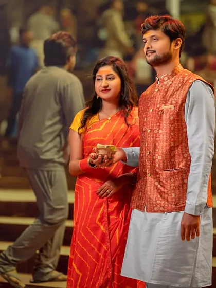 A moment of prayer and offering at the ghats. Dressed in vibrant traditional clothes, the couple's reverence and togetherness are the focus of this beautiful shot.