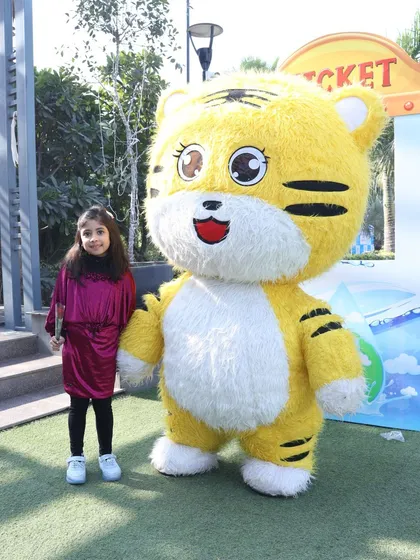 A young guest poses proudly next to our cheerful tiger mascot. Our performers are great at making every child feel special.