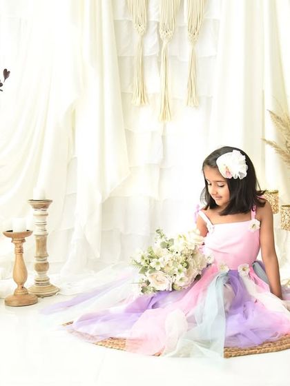 A dreamy and ethereal portrait for a fifth birthday. The pastel rainbow dress and soft, bright background give this photo a magical feel.