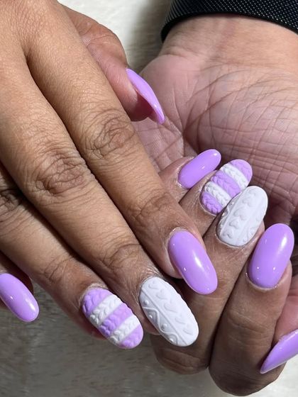 A full view of the lavender sweater nails. The combination of solid lavender and textured white accent nails creates a unique and stylish winter look.