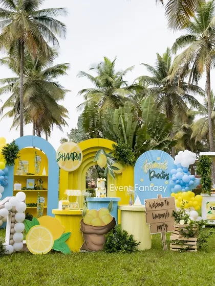 A bright and sunny lemonade-themed party, perfect for an outdoor celebration. This cheerful setup features a fresh color palette of yellow and blue, a lemonade stand prop, custom signage, and oversized lemon cutouts, making for a zesty and unique birthday experience.