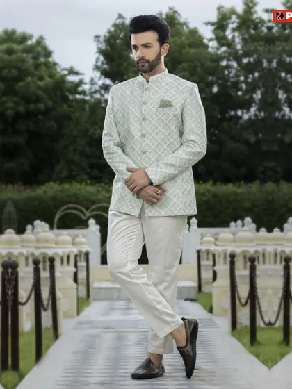 This pastel green Jodhpuri suit offers a unique color choice for festive wear. The subtle geometric print on the jacket, paired with off-white trousers, makes for a stylish and modern ethnic outfit.
