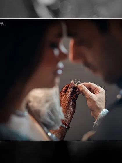 An artistic, over the shoulder view of the ring exchange, creating a sense of being right there in the moment with the couple.