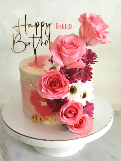 To celebrate a 40th birthday in style, I made this stunning pink floral cake as a surprise from Sheetal. The watercolor pink effect, gold leaf, and cascade of fresh pink roses and daisies made for a beautiful and feminine design.
