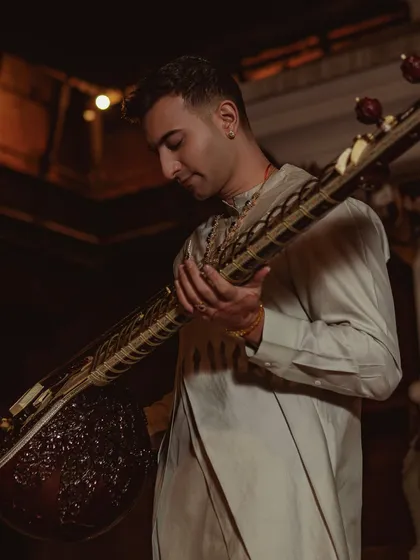 A softer moment from the Nepal shoot, showing the beautiful drape of the outfit and the intricate carving on the sitar.