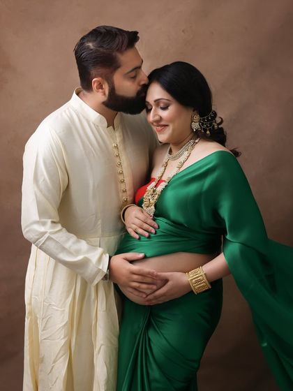 A beautiful portrait of love and tradition. The husband's tender kiss on his wife's forehead, both in traditional attire, makes for a heartwarming and culturally rich image.