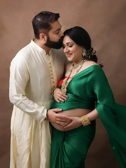 A beautiful portrait of love and tradition. The husband's tender kiss on his wife's forehead, both in traditional attire, makes for a heartwarming and culturally rich image.