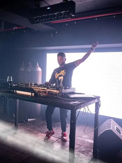 A full shot of me on stage at Cyclone Club, illuminated by a single beam of light.