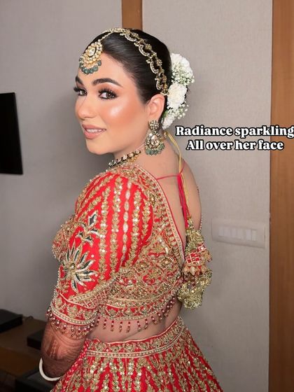 Radiance is key. This bride's glowing skin and sparkling eyes are the focus of her traditional red bridal look, creating a perfect blend of modern glam and classic style.