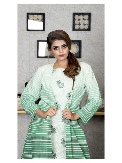 A model wearing a layered ensemble featuring a block-printed inner dress and a striped green jacket. This is an example of how I play with prints and layers to create contemporary Indian wear.