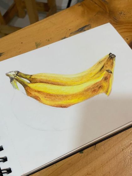 A work-in-progress showing how to build up layers with colored pencils to create a realistic banana sketch.