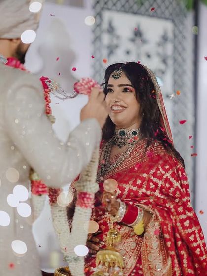 The Varmala exchange, a moment of love and commitment, beautifully captured with soft lighting and a shower of petals. We stage these key moments to feel both intimate and magical.