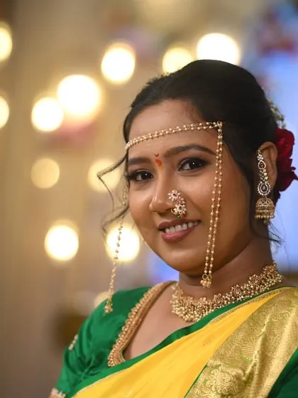 A close-up of a bride's Vidhi look, featuring a beautiful smile and glowing makeup. The bokeh background highlights the bride's features and the detailed work on her nath and bindi.