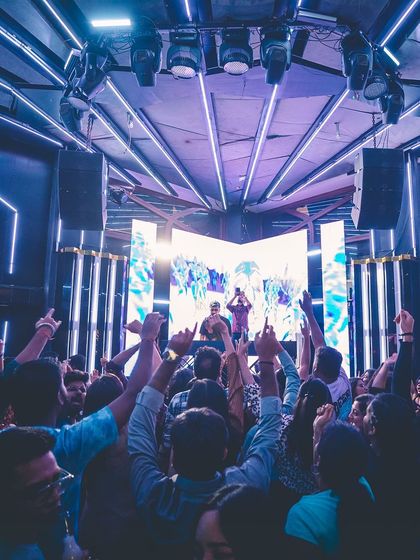 A wide shot showing the impressive lighting rig at Flo. The purple neon lights create a cool, futuristic aesthetic.