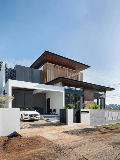 The exterior of the 'Open Sky Residence' is a masterful composition of wood, glass, and concrete, with deep overhangs and a dynamic, multi-layered form.