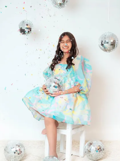 Celebrating a 10th birthday with a fun and vibrant photoshoot. The confetti and disco balls create a perfect party atmosphere.