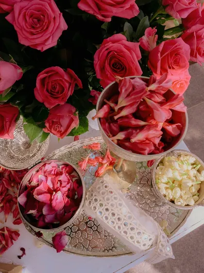 A beautiful flat-lay of fresh rose petals and mogra in ornate silver bowls, ready for the Chooda ceremony rituals, showcasing our attention to even the smallest details.