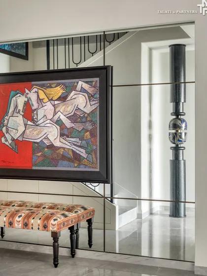 A mirrored wall in the "Nostalgia by the Sea" duplex reflects a bold piece of equestrian art and a sculptural totem. This home is a nostalgic retreat that beautifully intertwines past and present with a deep connection to cultural roots.