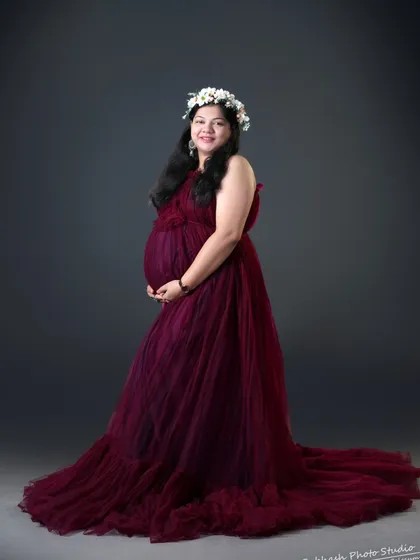 A classic studio maternity portrait in our wine-colored tulle gown. The floral crown adds a touch of softness to the elegant look.