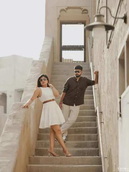 A stylishly posed shot of the couple on a staircase, exuding confidence and modern romance.