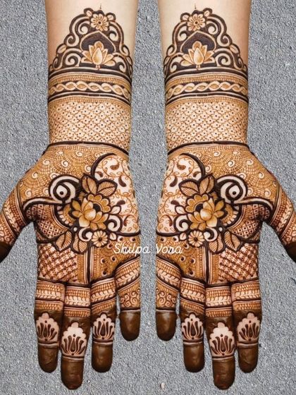 A beautiful floral design with a central lotus, surrounded by delicate 'jaal' work and patterns on the fingers.
