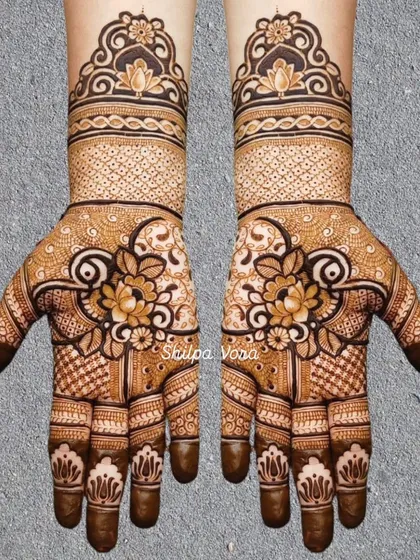A beautiful floral design with a central lotus, surrounded by delicate 'jaal' work and patterns on the fingers.