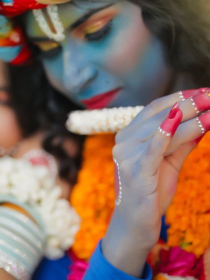 A detailed close-up of the hand and flute, showing the intricate details of the makeup and styling.