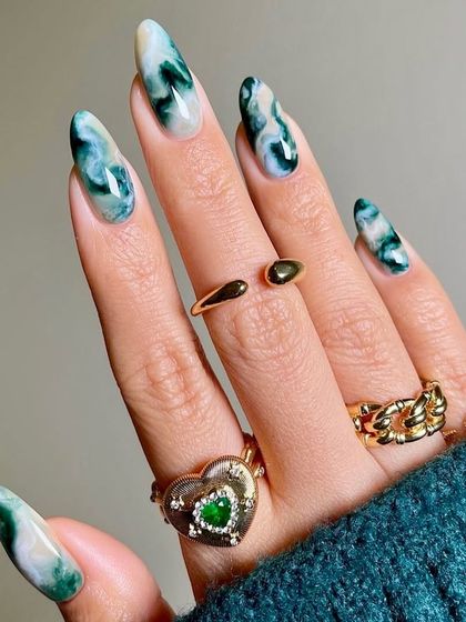 Inspired by natural jade stone, this design features a beautiful green and white marble effect on long, pointed nails. The swirling patterns mimic the look of real quartz, creating a unique and earthy design.